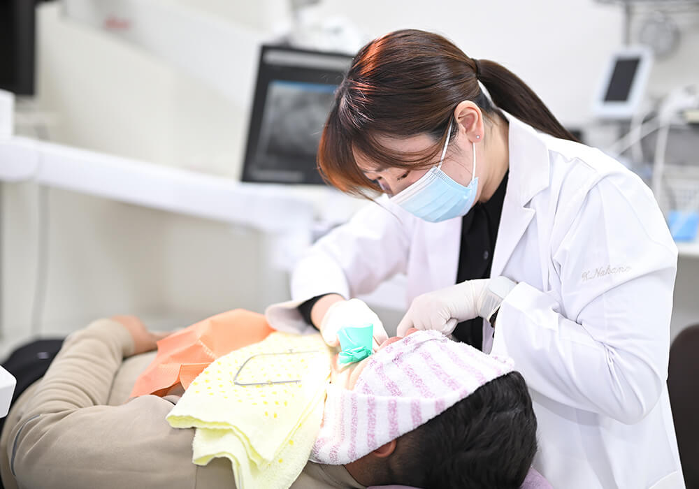 患者の歯の状態を確認する歯科医師